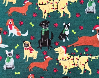 May include: A green fabric with a repeating pattern of dogs wearing Santa hats and Christmas lights. The dogs are in various breeds and colors, including black, brown, white, and yellow. The fabric also features red paw prints and white bone shapes.