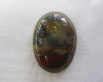 May include: A smooth, oval-shaped cabochon gemstone with a layered pattern of brown, black, and red colors.