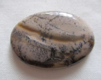 May include: A smooth, oval-shaped stone with a light brown and gray mottled pattern. The stone has a natural, polished finish.
