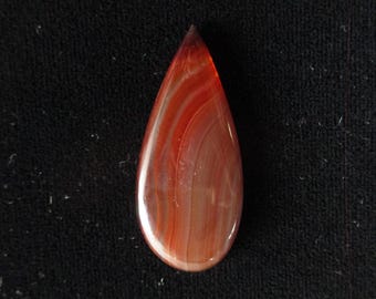 May include: A teardrop-shaped pendant made of red agate with white and orange banding.