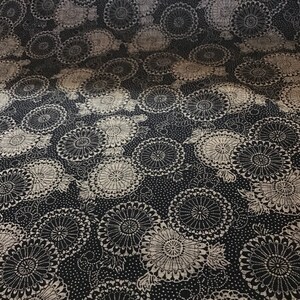 May include: Black fabric with a white floral pattern. The pattern features repeating circles with a radial design.