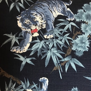May include: A blue and white tiger print fabric with a dark blue background. The tiger is depicted in a jungle setting with bamboo plants and other foliage.
