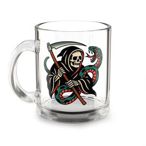 Può includere: Una tazza in vetro trasparente con una grafica colorata raffigurante uno scheletro incappucciato che impugna una falce, intrecciato con un serpente verde e rosso. Il disegno è stampato sulla parte anteriore del contenitore, dotato di manico.
