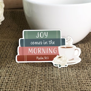 May include: A sticker with a stack of books, a cup of coffee, and a flower. The books have the text "JOY comes in the MORNING" and "Psalm 30:5".