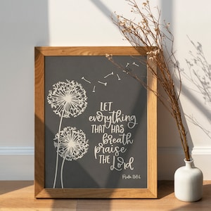 May include: A framed print with a dark gray background featuring two white dandelion illustrations and the text "Let everything that has breath praise the Lord. Psalm 150:6."