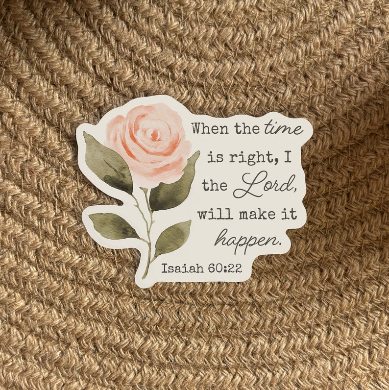 May include: A white sticker with a watercolor illustration of a pink rose. The sticker has a quote from the Bible, Isaiah 60:22, which reads "When the time is right, I the Lord, will make it happen."