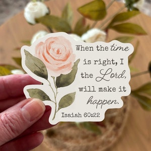 May include: A white sticker with a watercolor illustration of a pink rose and the text "When the time is right, I the Lord, will make it happen. Isaiah 60:22"