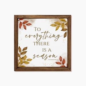 May include: Square wooden framed sign with the quote "To everything there is a season" in gold script. The sign features watercolor-style autumn leaves in shades of red, yellow, and brown in each corner. The text "Ecclesiastes 3:1" is in the bottom right corner.