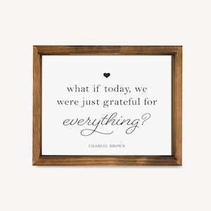 May include: A framed print with a white background and a black heart at the top. The text reads "what if today, we were just grateful for everything?" with the words "everything" in cursive. The text "CHARLIE BROWN" is printed below the quote.