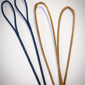 Può includere: Tre tipi diversi di corde per arco, una nera, una marrone e una dorata.