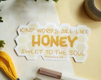May include: A yellow and white honeycomb-shaped sticker with the text "Kind words are like honey sweet to the soul" and the Bible verse "Proverbs 16:24".