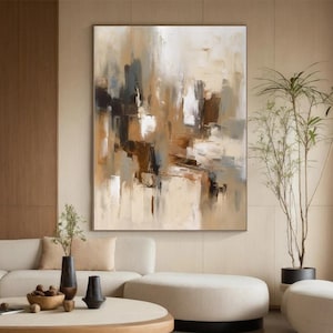 Puede incluir: Pintura abstracta con colores marrones, beige y grises en un estilo contemporáneo. La pintura está colgada en una pared en un salón con un sofá, una mesa de café y plantas.