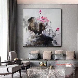 K&ouml;nnte beinhalten: Abstrakte Malerei mit rosa Blumen auf dunkelgrauem Hintergrund. Das Gem&auml;lde ist gerahmt und h&auml;ngt an einer grauen Wand in einem Wohnzimmer.