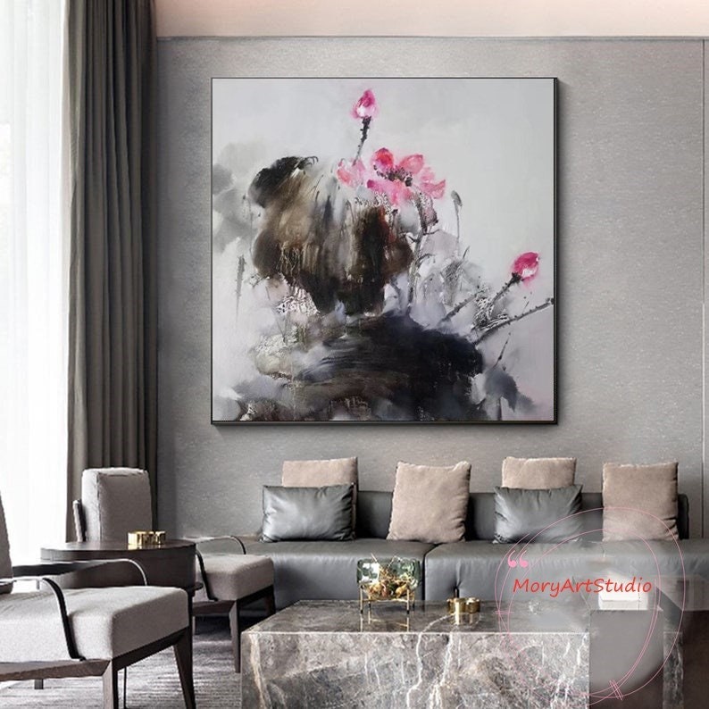 K&ouml;nnte beinhalten: Abstrakte Malerei mit rosa Blumen auf dunkelgrauem Hintergrund. Das Gem&auml;lde ist gerahmt und h&auml;ngt an einer grauen Wand in einem Wohnzimmer.