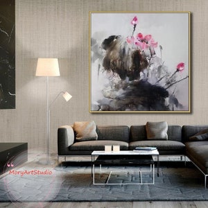 K&ouml;nnte beinhalten: Abstrakte Malerei mit rosa Blumen, grauen und schwarzen Pinselstrichen auf wei&szlig;em Hintergrund. Das Gem&auml;lde ist in einem goldenen Rahmen gerahmt und h&auml;ngt an einer Wand in einem Wohnzimmer.