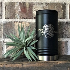 May include: Black stainless steel travel mug with a silver lid and a black and silver logo that reads "World's Toughest Iron Butt Association Motorcycle Riders".