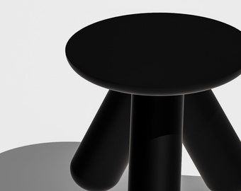 May include: A black, three-legged stool with a round seat. The stool is made of a smooth, glossy material.