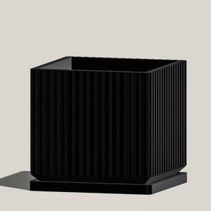 May include: A black rectangular planter with a ribbed design and a square base.