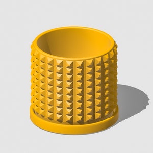 May include: A yellow ceramic planter with a textured, geometric design. The planter has a wide, round opening and a slightly smaller base.