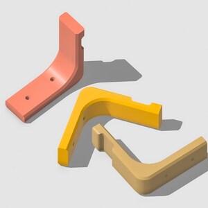Könnte beinhalten: Drei Eckregalböcke in verschiedenen Farben: Koralle, Gelb und Beige. Die Böcke sind aus Kunststoff und haben ein schlichtes, modernes Design.