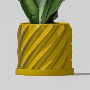 May include: A yellow planter with a spiral design. The planter has a wide base and a narrow top. The planter is made of a smooth material.