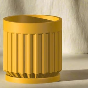 May include: A cylindrical, yellow planter with vertical ribbed detailing. The planter has a circular base and a smooth rim. The design is modern and minimalist, suitable for indoor or outdoor use. The planter is approximately 5 inches tall and 4 inches in diameter.