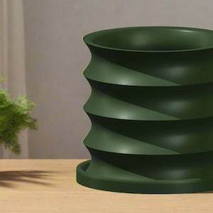 May include: A dark green, cylindrical planter with a unique, spiraling design. The planter sits on a matching base and is made of a solid material. The design features a series of curved, horizontal bands, creating a textured appearance. The planter is empty.