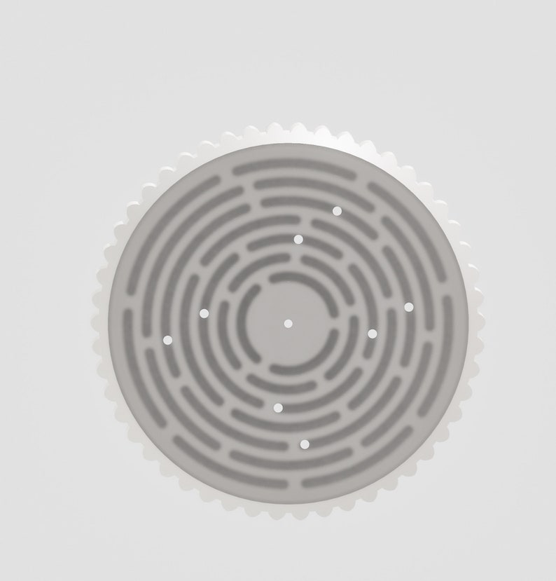 May include: A white circular shower drain with a textured surface and multiple small holes.