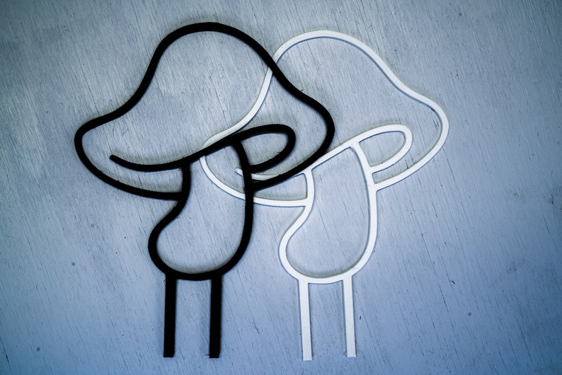 Peut inclure: Deux contours en forme de champignon, l'un noir et l'autre blanc, sont superpos&eacute;s. Les contours sont simples et abstraits, avec un sommet arrondi et une tige &agrave; trois pattes.
