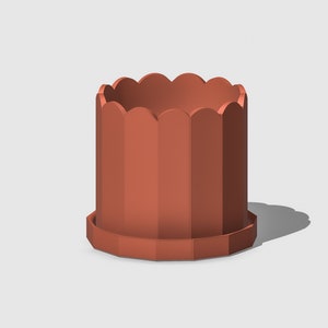 Peut inclure: Un pot de fleurs en terre cuite de couleur terracotta avec un bord festonné et un motif cannelé. Le pot est fait d'un matériau lisse et mat.