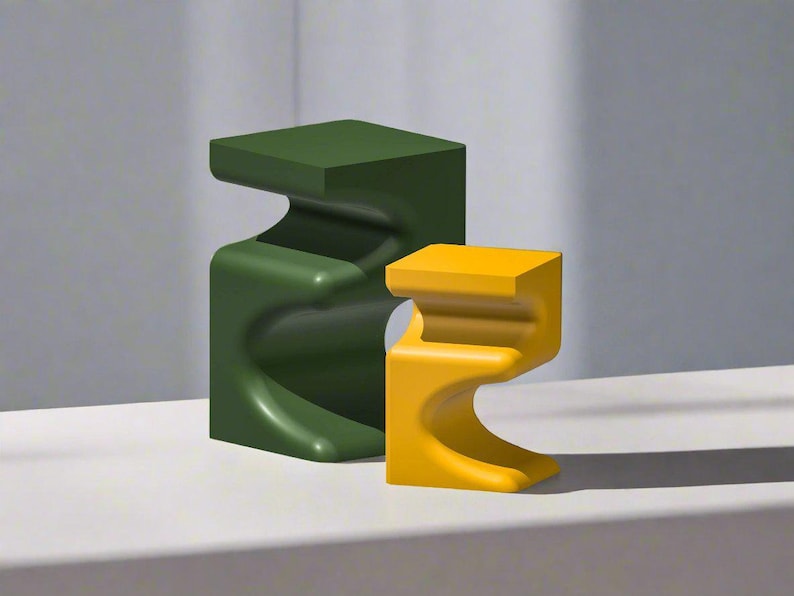 Pu&ograve; includere: Due sculture astratte moderne, una verde scuro e l'altra gialla. Entrambe hanno una parte superiore quadrata e un design curvo a forma di onda. Le sculture sono su una superficie bianca.