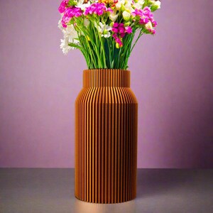 K&ouml;nnte beinhalten: Eine Holzvase mit vertikalen Rillen, in einem warmen Braunton lackiert, h&auml;lt einen Strau&szlig; aus rosa und wei&szlig;en Blumen.