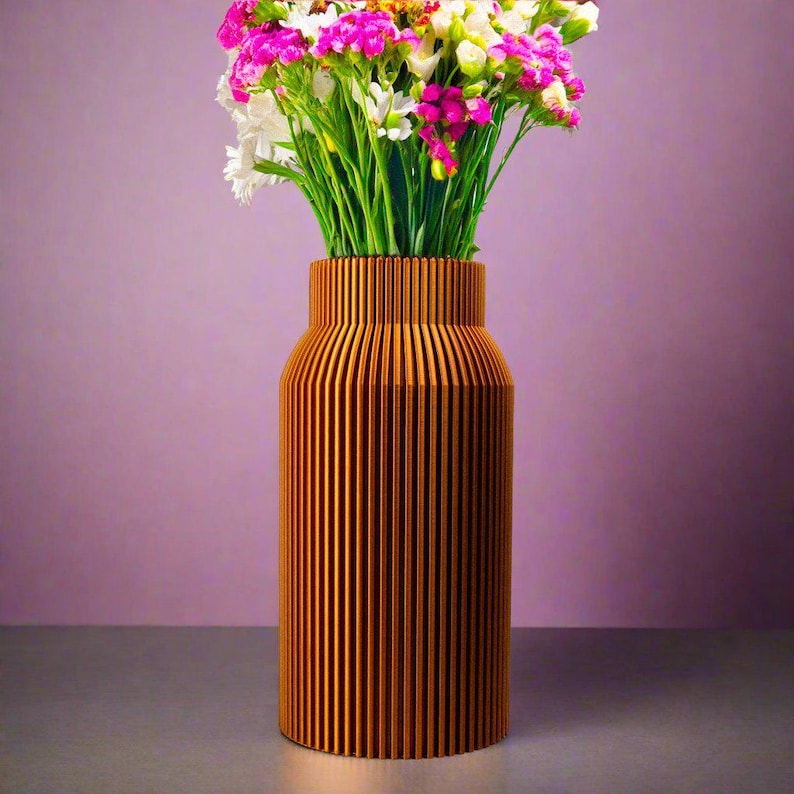 K&ouml;nnte beinhalten: Eine Holzvase mit vertikalen Rillen, in einem warmen Braunton lackiert, h&auml;lt einen Strau&szlig; aus rosa und wei&szlig;en Blumen.