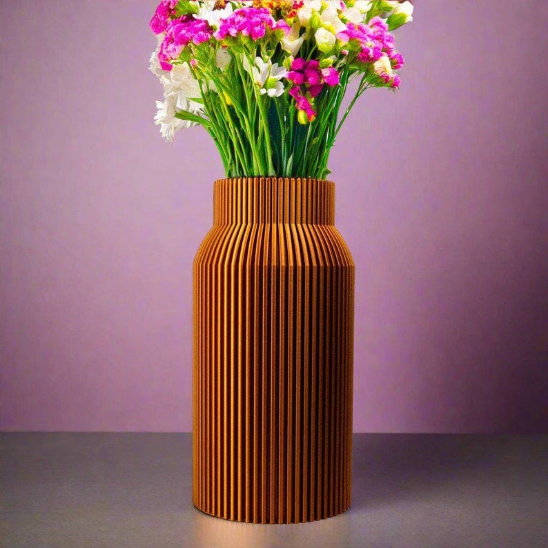 May include: A wooden vase with vertical grooves in a light brown color. The vase is filled with a bouquet of pink and white flowers.
