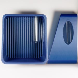 May include: A blue plastic desk organizer set. The set includes a rectangular tray with vertical ridges and a separate angled piece with an oval cutout. A clear, cylindrical tube is placed in the tray and the angled piece.