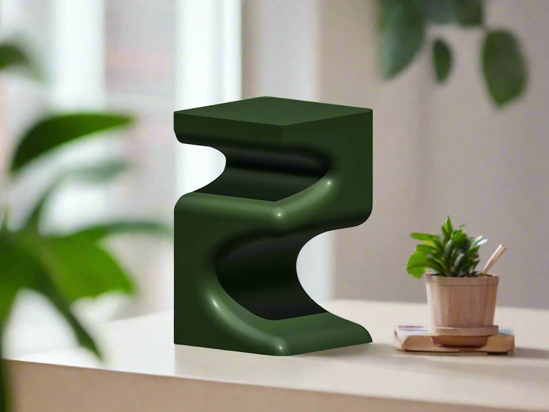 Pu&ograve; includere: Un tavolino laterale moderno verde scuro con un design curvo unico. Il tavolo ha un piano e una base quadrati, con una forma fluida e organica in mezzo. Il tavolo &egrave; alto circa 46 cm.