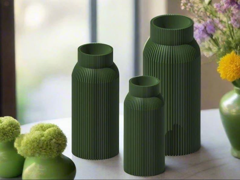 K&ouml;nnte beinhalten: Drei gr&uuml;ne Keramikvasen mit geripptem Design. Die Vasen sind in verschiedenen Gr&ouml;&szlig;en und in einer Reihe auf einem Tisch angeordnet.