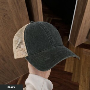 Op de afbeelding: Zwarte truckerpet met een mesh achterkant en een gebogen klep. De voorkant van de pet is effen zwart en de mesh achterkant is beige. Een klassieke, casual stijl.