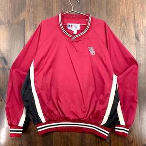 Könnte beinhalten: Rote XL-Pulloverjacke mit schwarzen und weißen Akzenten. Verfügt über einen V-Ausschnitt mit weißen und schwarzen Streifen und ein USC-Logo. Der Saum und die Manschetten sind gerippt und mit weißen und schwarzen Streifen versehen.
