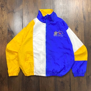 Peut inclure: Une veste coupe-vent jaune, blanche et bleue avec une fermeture éclair. La veste a un logo Kentucky State Lodge sur le devant.
