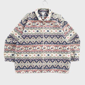 May include: A long-sleeve fleece jacket featuring a full-length front zip and a high collar. The garment displays a repeating geometric and floral pattern in shades of dusty pink, slate blue, cream, and sage green across the entire surface.
