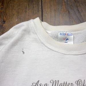 May include: White sweatshirt with a small hole near the neckline. The tag reads "Jerzees" with a small logo. The text "As a Matter Of" is visible at the bottom of the image.