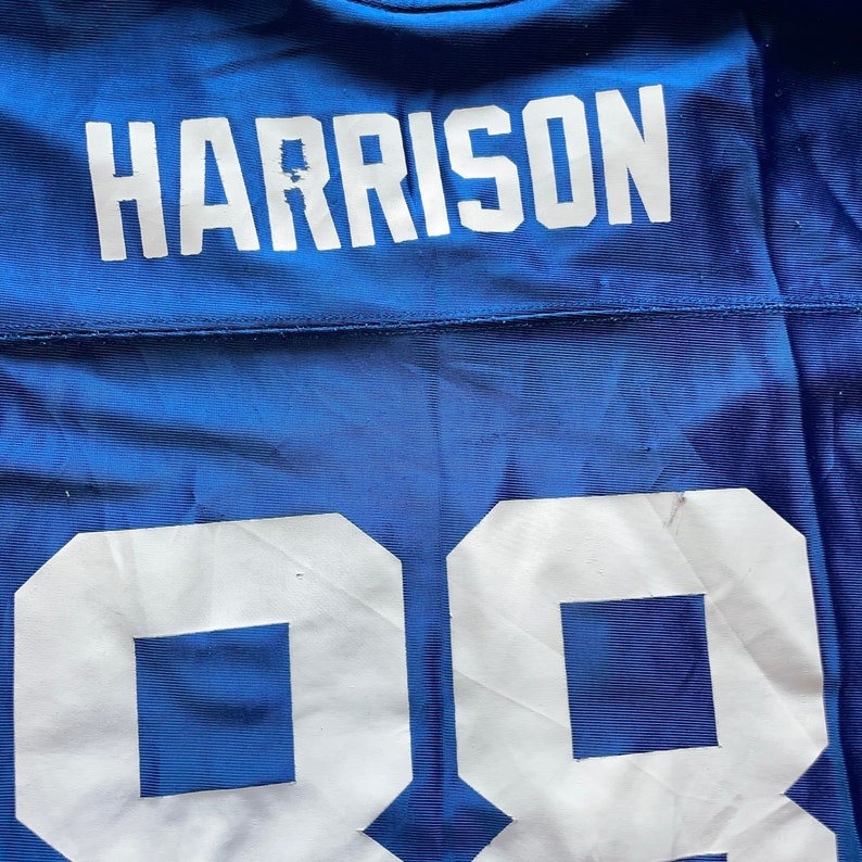 May include: A blue football jersey with the name "HARRISON" and the number "98" printed on the back in white.