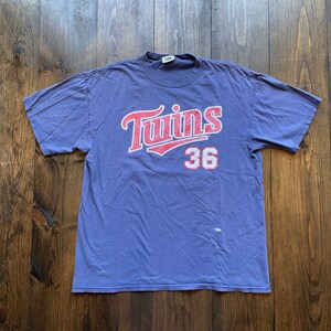 May include: A vintage purple t-shirt with a faded red and white "Twins 36" graphic.