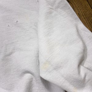 May include: White sweatshirt with a slight discoloration on the fabric.