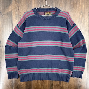 Op de afbeelding: Een witte keramische mok met een zwarte handgreep en de tekst "But First, Coffee" in een vetgedrukte, zwarte letter. De mok staat tegen een vage achtergrond, wat een gezellige setting suggereert.