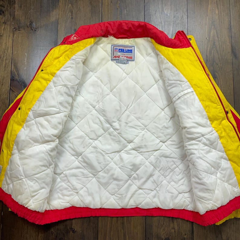 May include: Red and yellow reversible jacket with a white quilted lining. The jacket has a zip closure and a Pro Line logo on the inside.