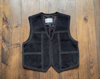 May include: A black suede vest with a V-neck and decorative stitching around the edges. The vest has a label that reads "GIII" on the front.