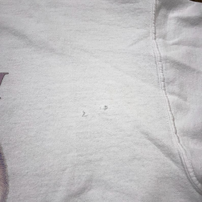 May include: White t-shirt with a small hole in the fabric.
