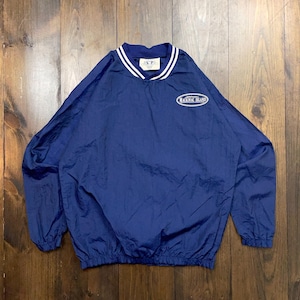 May include: A navy blue windbreaker jacket with white trim around the collar and cuffs. The jacket has a white oval logo with the text "Mackinac Island" on the front.